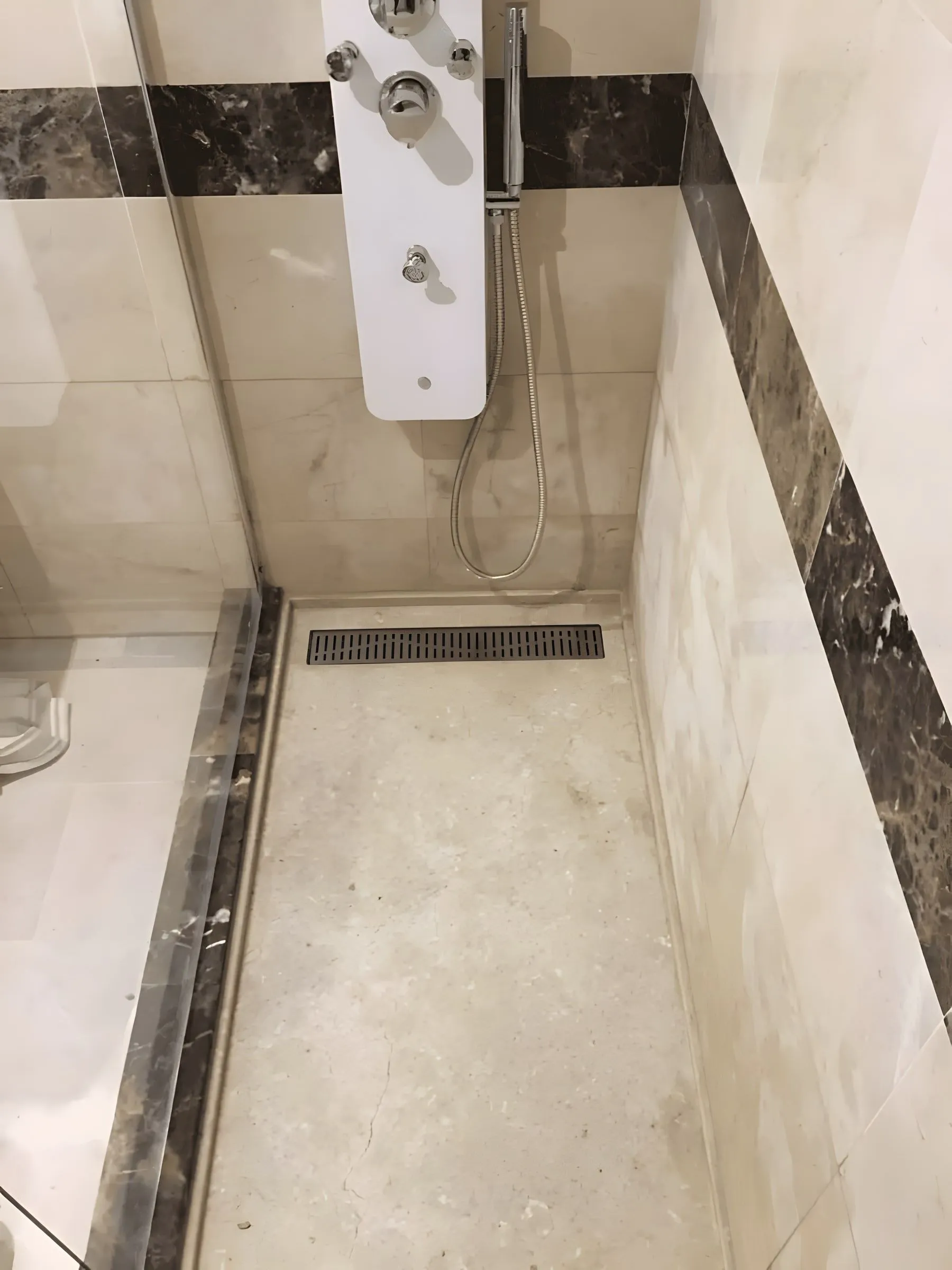 Shower with marble cladding and dark band