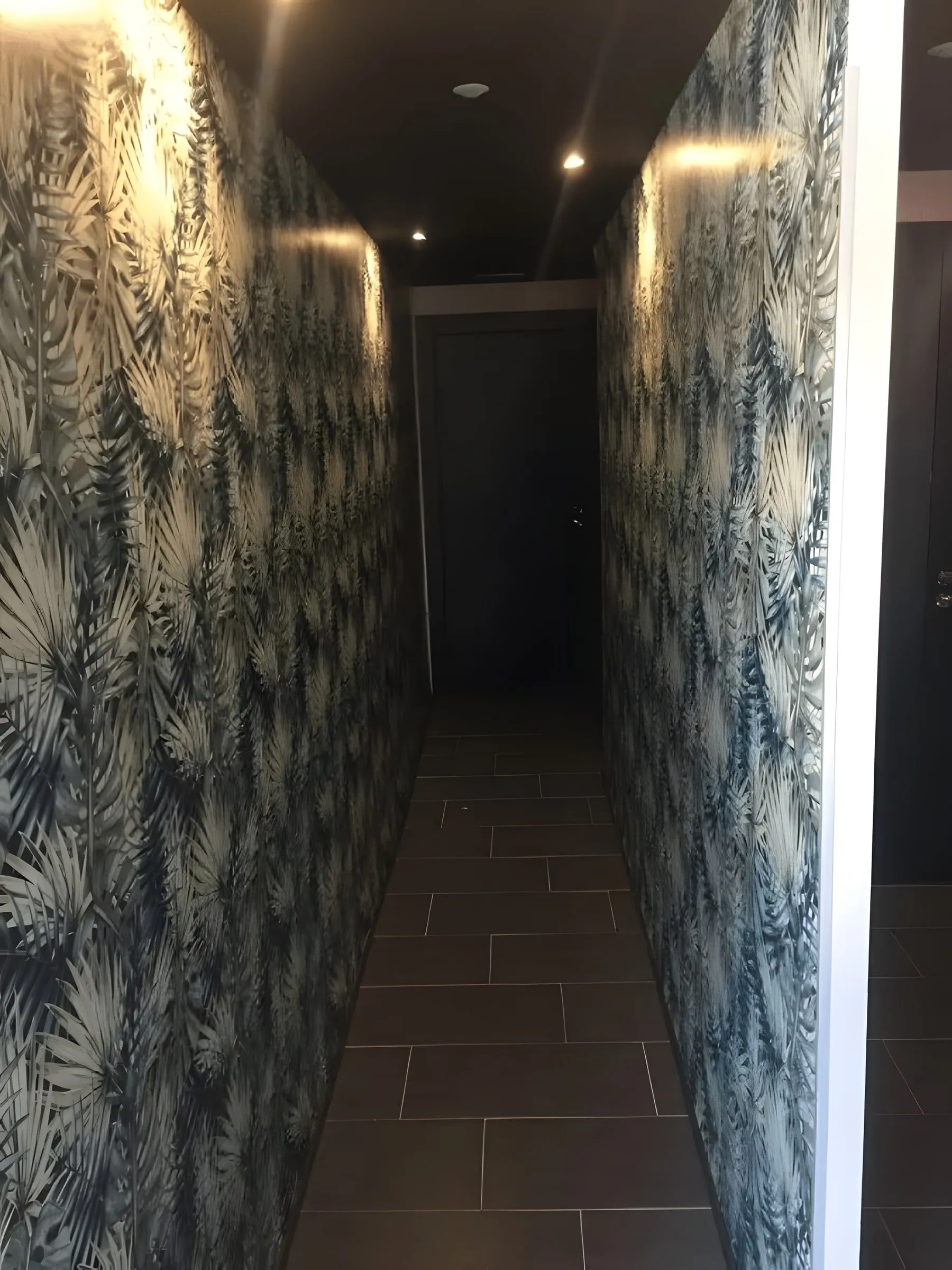 Corridor to the restrooms with tropical wallpaper